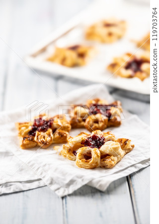 Sweet dessert pastries made of puff pastry with strawberry jam filled with caramelized apple 119703764