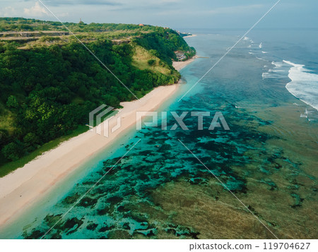 Coastline with green cliffs and ocean in Bali island. Aerial view of tropical vacation beach Coastline with green cliffs and ocean in Bali island. Aerial view of tropical vacation beach 119704627