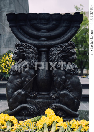 Monument adorned with flowers and daffodils, commemorating the Warsaw Ghetto Uprising 119707192
