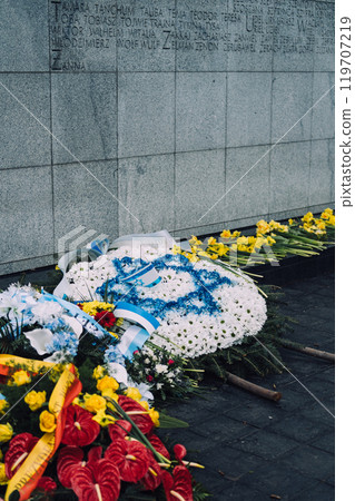 Wreaths and flowers laid at memorial wall, commemorating the Warsaw Ghetto Uprising 119707219