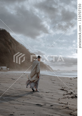 Woman standing on the winter beach 119707350