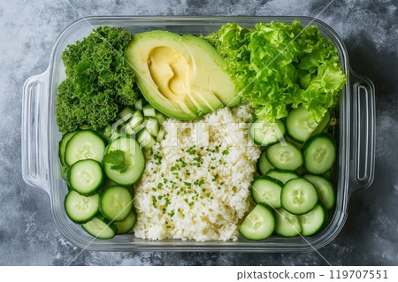 Healthy green vegan salad bowl with avocado, rice, and fresh vegetables in glass container 119707551