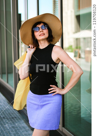 Stylish woman in hat on hot summer day nset shopping from store Stylish woman in hat on hot summer day nset shopping from store 119708120
