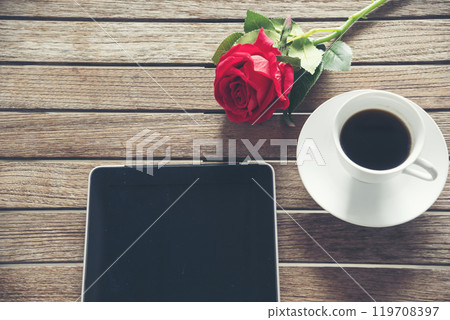 Top view office desk smart tablet document paper, coffee cup roses on wood table with copy space. Tabletop notebook office empty blank white paper pen coffee cup to display workspace wood background Top view office desk smart tablet document paper, coffee cup roses on wood table with copy space. Tabletop notebook office empty blank white paper pen coffee cup to display workspace wood background 119708397