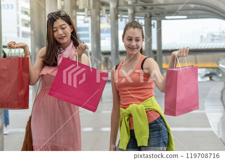 Shopaholic Women holding shopping bags ,money ,credit card person at shopping malls.Fashionable Woman love online website with sales tag on black Friday. E-commerce fashion digital marketing lifestyle 119708716
