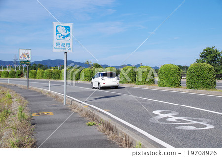 A white station wagon driving along Melody Road near Yonago Kitaro Airport in Sakaiminato, Tottori Prefecture A white station wagon driving along Melody Road near Yonago Kitaro Airport in Sakaiminato, Tottori Prefecture 119708926
