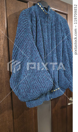 Handmade knitted products. Knitted fabric made of dark threads. Woman pullover. Handmade knitted products. Knitted fabric made of dark threads. Woman pullover. 119709852