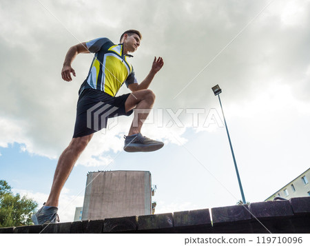 Young man running in park 119710096