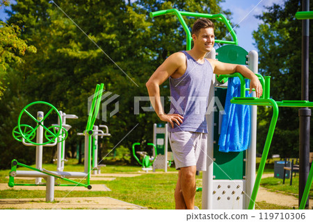 Man working out in outdoor gym Man working out in outdoor gym 119710306