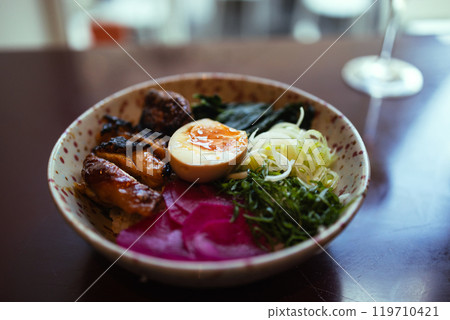 Japanese famous delicious ramen with different ingredients Noodle soup with shiitake, egg and pak choi cabbage on dark background. Japanese famous delicious ramen with different ingredients Noodle soup with shiitake, egg and pak choi cabbage on dark background. 119710421