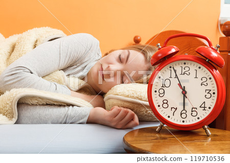 Woman sleeping in bed with set alarm clock. Woman sleeping in bed with set alarm clock. 119710536
