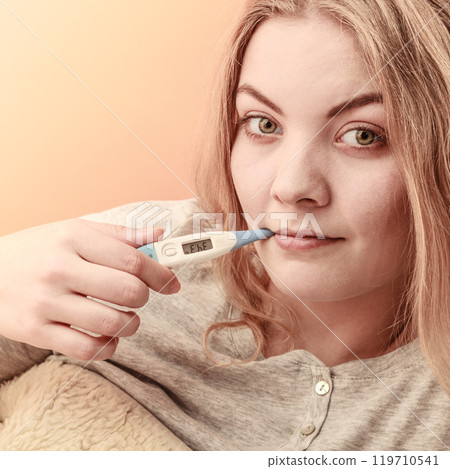 Sick ill woman with digital thermometer in mouth. 119710541
