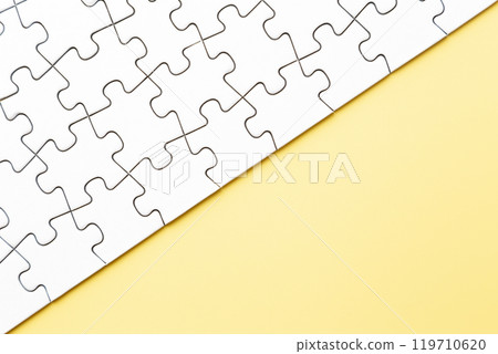 Plain jigsaw puzzle on a yellow background 119710620