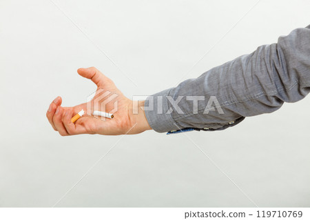Broken cigarette on male hand. 119710769