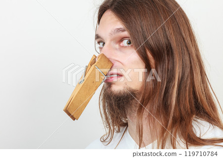 Man with clothespin on nose Man with clothespin on nose 119710784
