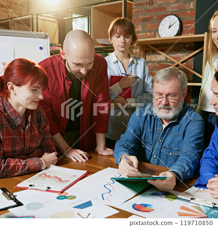 Business meeting with professionals focused on achieving company objectives through collaboration and data-driven insights. 119710850