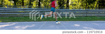 side view male athlete running marathon race on asphalt road 119710918