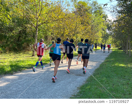 rear view group of athletes running half marathon race in park in Monza 119710927