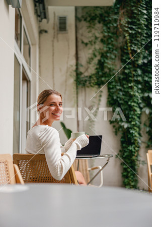 A Woman Absolutely Enjoying Her Hot Coffee While in a Cozy Indoor Setting Around Her 119710984