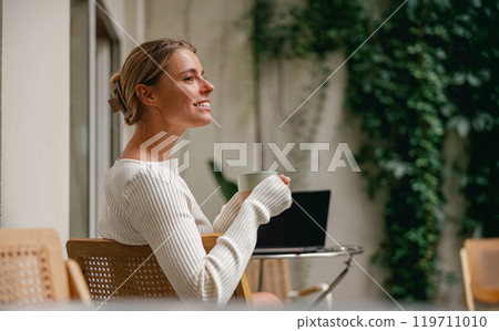 A Woman Enjoying a Hot Cup of Coffee in a Cozy and Inviting Space with a Relaxed Ambiance 119711010