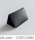 Black leather triangular wallet on plain surface 119711062