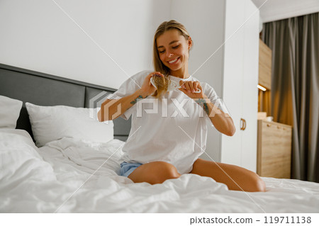 A Joyful Woman is Enjoying Her Morning in a Cozy Hotel Room, Embracing Comfort and Peace A Joyful Woman is Enjoying Her Morning in a Cozy Hotel Room, Embracing Comfort and Peace 119711138