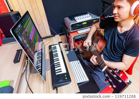 asian male musician, producer playing acoustic guitar for recording in home studio asian male musician, producer playing acoustic guitar for recording in home studio 119711288
