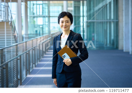 穿著西裝的中層女商人站在走廊上 119711477
