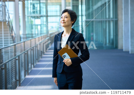 穿著西裝的中層女商人站在走廊上 119711479