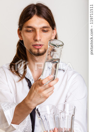 Cheerful barman filling glasses. 119711511
