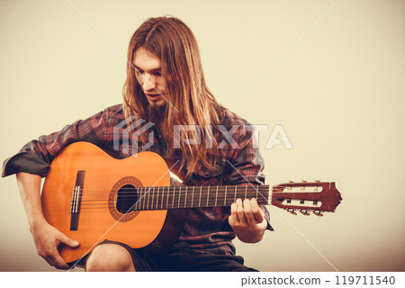 Sitting man playing guitar. 119711540