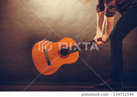Rock musician destroys his guitar. 119711544