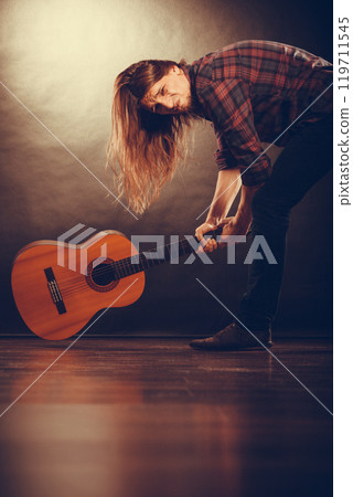 Rock musician destroys his guitar. 119711545