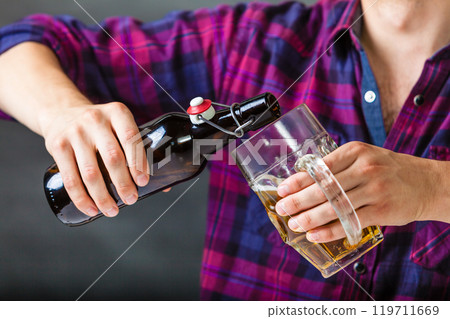 Tapster fills stein from bottle. Tapster fills stein from bottle. 119711669