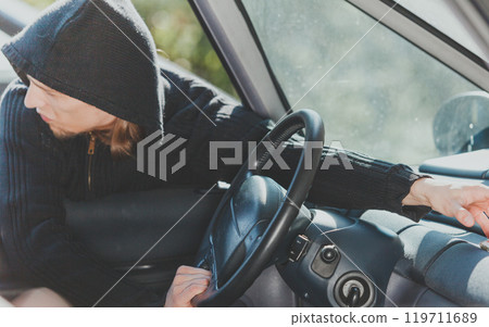 Burglar thief breaking into car and stealing Burglar thief breaking into car and stealing 119711689