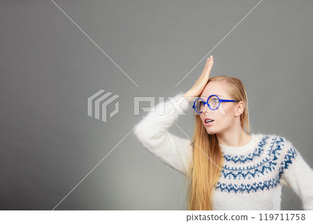 Nerd blonde woman holding hand on forehead 119711758