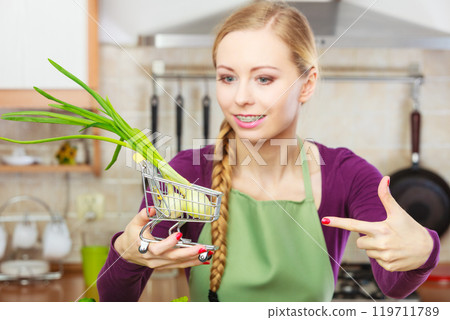 Woman holding shopping cart with chive inside Woman holding shopping cart with chive inside 119711789
