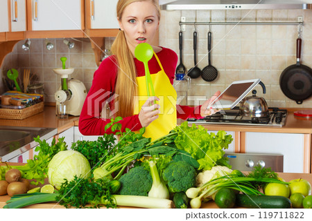 Woman having green vegetables thinking about cooking Woman having green vegetables thinking about cooking 119711822
