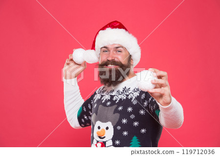 happy bearded man play with new year decorative snowball wearing funny knitted sweater and santa claus hat for celebrating new year holiday, happy new year. christmas happy bearded man play with new year decorative snowball wearing funny knitted sweater and santa claus hat for celebrating new year holiday, happy new year. christmas 119712036