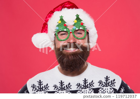 Good mood. Santa is coming. Santa man wear christmas tree party glasses. Happy bearded man with santa look. Holiday accessories for santa party. Christmas and New Year celebration. Emotional face Good mood. Santa is coming. Santa man wear christmas tree party glasses. Happy bearded man with santa look. Holiday accessories for santa party. Christmas and New Year celebration. Emotional face 119712037