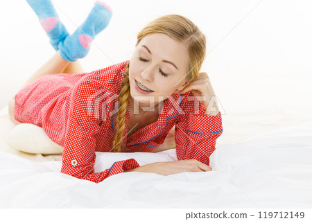 Smiling woman lying in bed 119712149