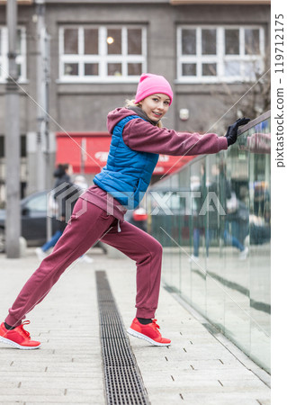 Sporty girl stretching outdoor on city street. Sporty girl stretching outdoor on city street. 119712175