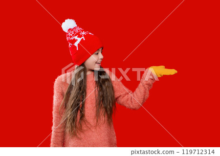 Teen girl kid isolated on red studio. Child winter fashion. Girl enjoying winter style. Teen girl wearing stylish new year hat. Childhood winter memories. Streetwear culture 119712314