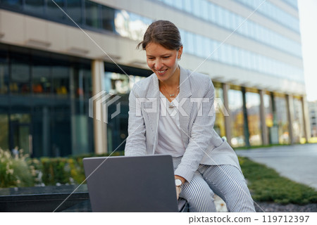 A Business Woman Diligently Working on Her Laptop While Enjoying the Outdoors in the Afternoon 119712397