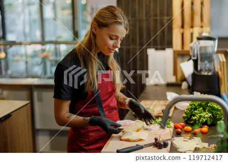 Culinary Expert Skillfully Preparing Fresh Ingredients in a Modern Kitchen Environment Culinary Expert Skillfully Preparing Fresh Ingredients in a Modern Kitchen Environment 119712417
