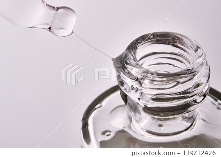 Close-up of a cosmetic bottle with a pipette showing the texture of the serum. 119712426