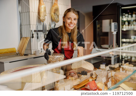 A Cheese Shop Employee Passionately Serving Customers with an Array of Fresh Products A Cheese Shop Employee Passionately Serving Customers with an Array of Fresh Products 119712500