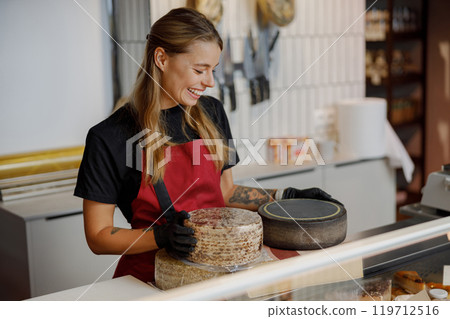 Dedicated Cheese Specialist in an Artisan Shop featuring a wide range of exquisite gourmet cheeses Dedicated Cheese Specialist in an Artisan Shop featuring a wide range of exquisite gourmet cheeses 119712516