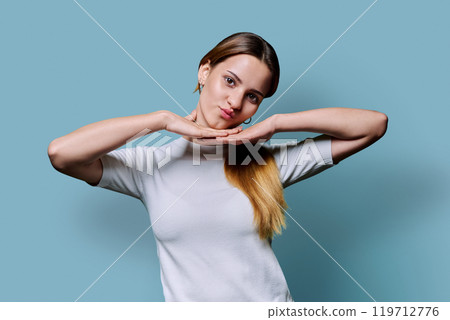 Portrait of beautiful young girl with long red hair looking at camera on blue background Portrait of beautiful young girl with long red hair looking at camera on blue background 119712776