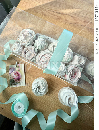 Marshmallow flowers in a gift box with a transparent lid. A card with the inscription in Russian Endless happiness. 119713554